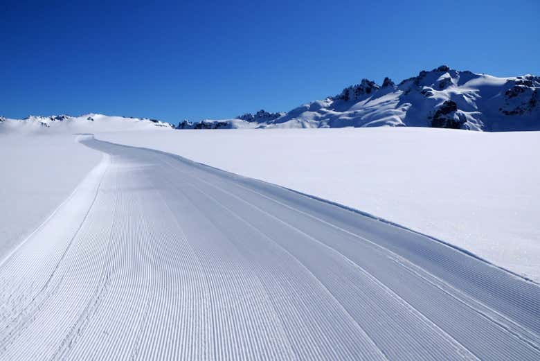 Ski down snowy slopes