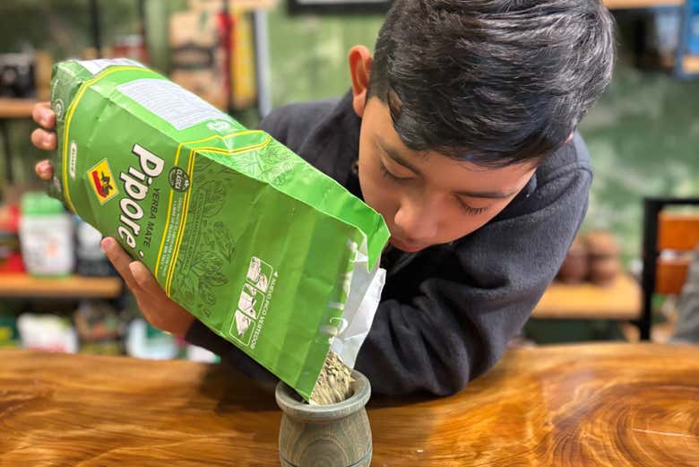 Um menino aprendendo a fazer mate argentino