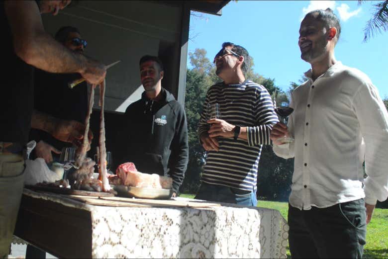 Tomando un vino mientras vemos cómo se hace el asado