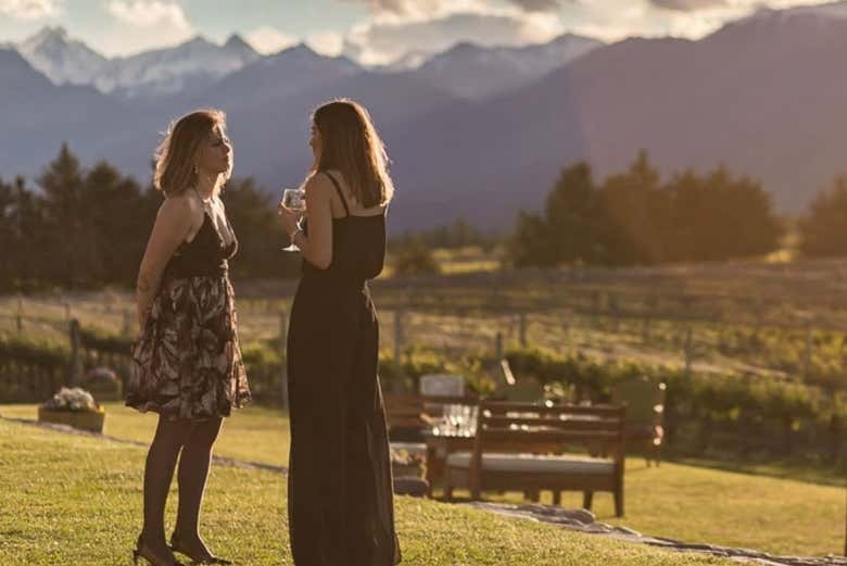 Tomando una copa de vino entre viñedos