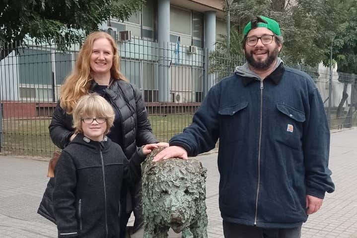 Familia posando con la escultura de un perrito