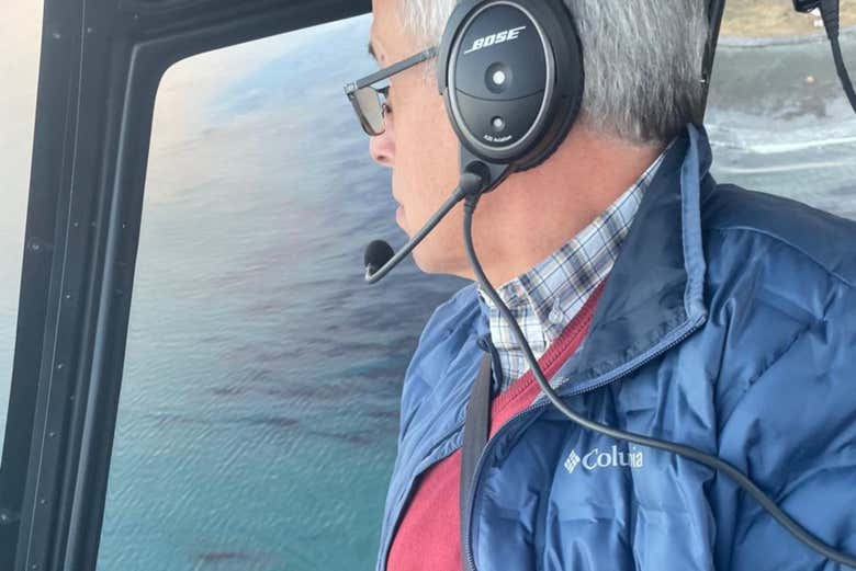 Un hombre pilotando un helicóptero sobre el agua