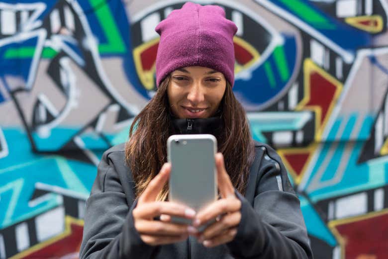 Tomándose un selfie ante un grafiti