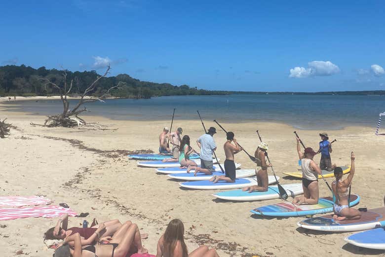 Un gruppo impara a fare paddleboard sulla spiaggia