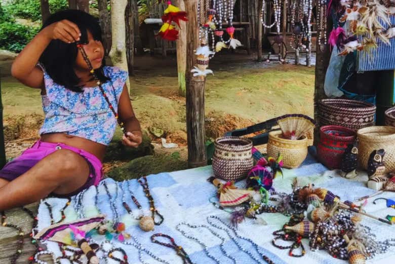 Una niña mostrando las artesanías indígenas de la aldea