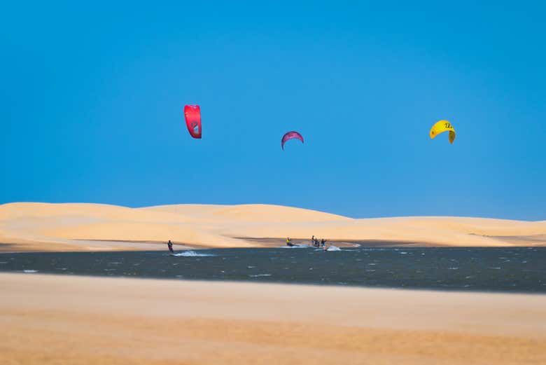 Praticando kitesurf com as dunas ao fundo