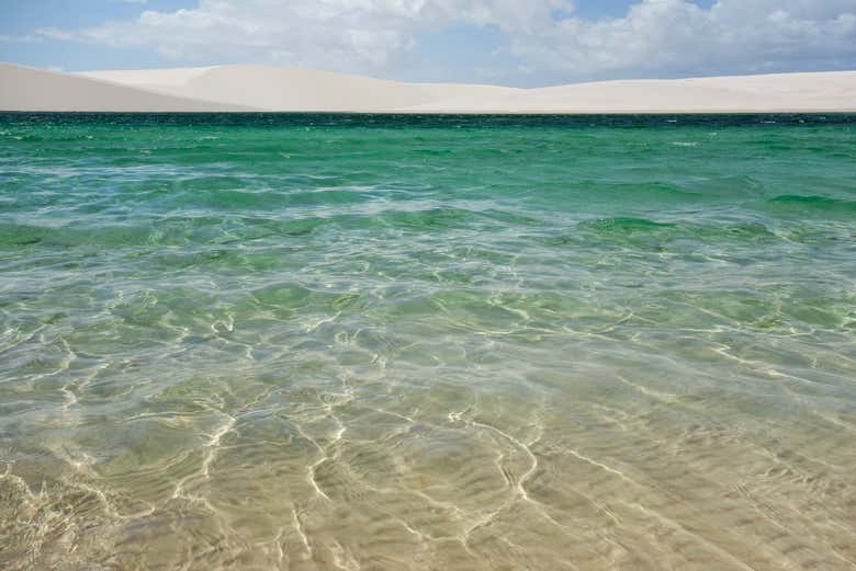 Água cristalina rodeada por dunas nos Lençóis Maranhenses