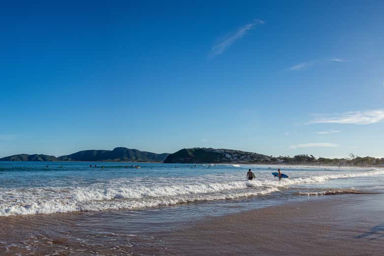 Entrando no mar com pranchas para começar a surfar