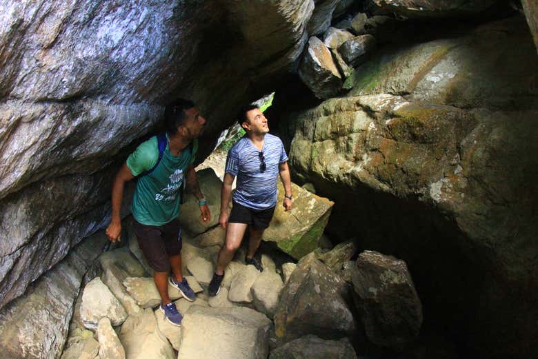 Passando por baixo das pedras da Trilha do Piquinho