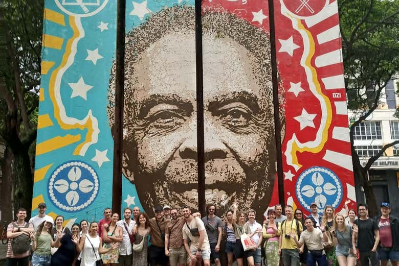 Posando em frente a um enorme grafite