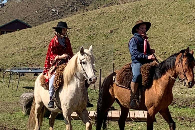 Casal andando a cavalo pela fazenda