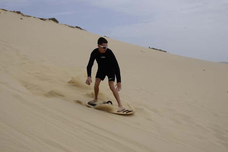 Praticando sandboarding nas dunas