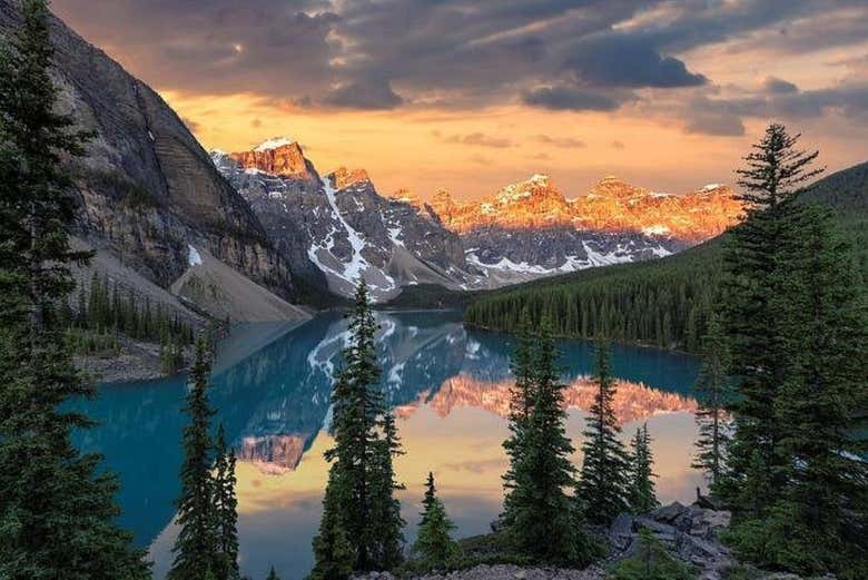 Os tons alaranjados do pôr do sol sobre a paisagem