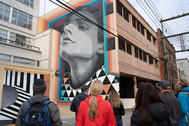 Grupo de turistas observando un mural del centro de Calgary