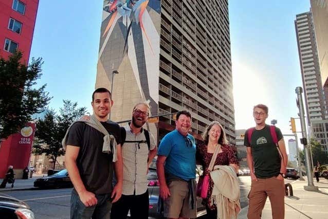 Grupo posando ante una obra de arte urbano en Calgary