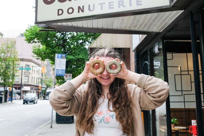Jeune femme mettant deux donuts sur ses yeux comme des lunettes
