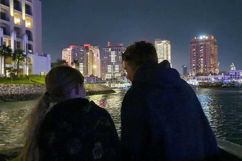 Dos personas disfrutando del paisaje de Doha por la noche