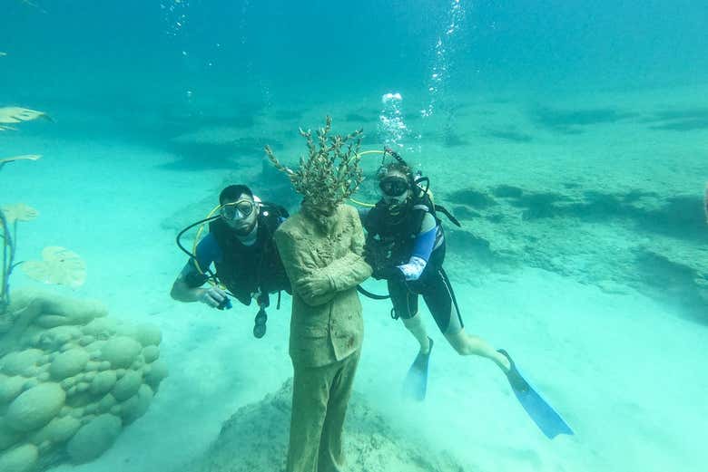 Two divers by a sculpture