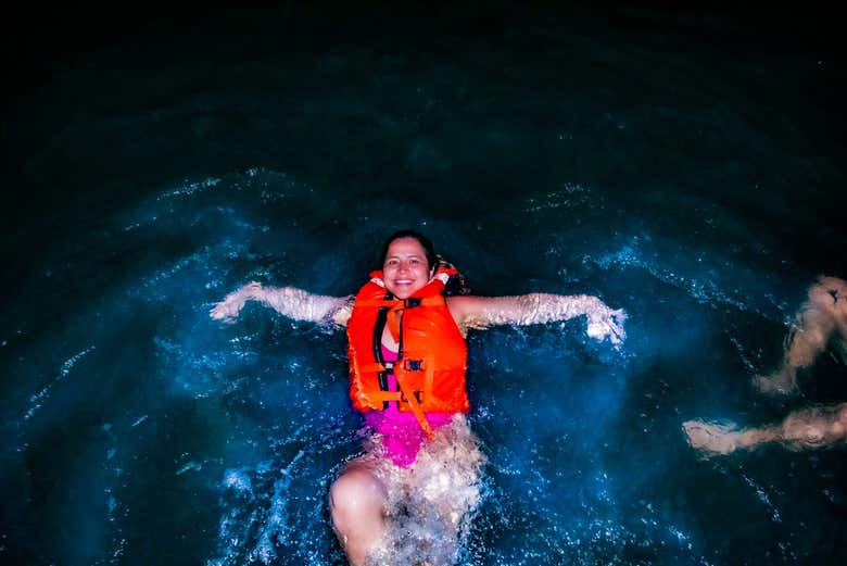 Una mujer nadando entre el plancton luminiscente