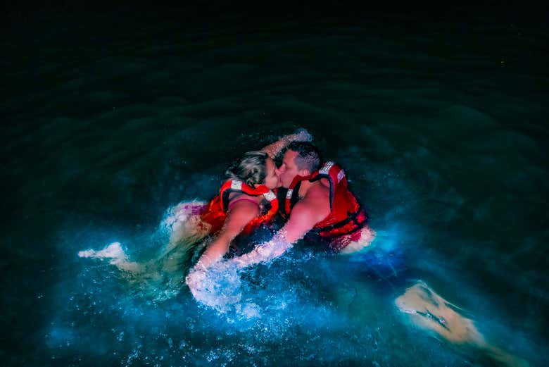 Besándose mientras nadan entre el plancton luminiscente