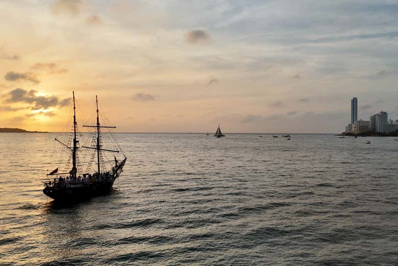 Barco pirata navegando pela baía de Cartagena ao entardecer