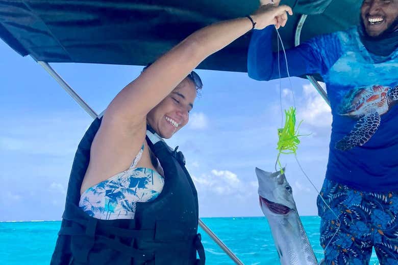 Una mujer feliz con su pez recién pescado