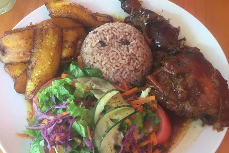 Un plato de pollo con arroz, ensalada y plátano