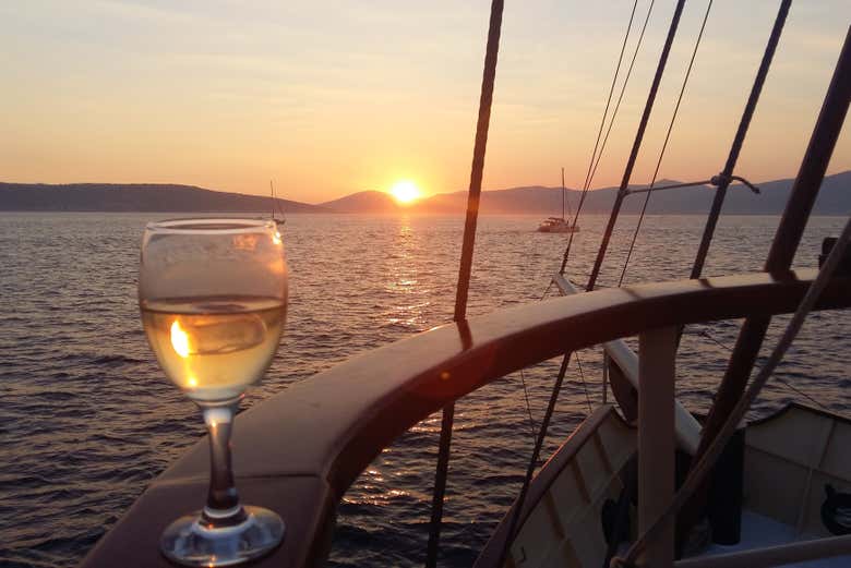 Uma taça de vinho com o pôr do sol ao fundo