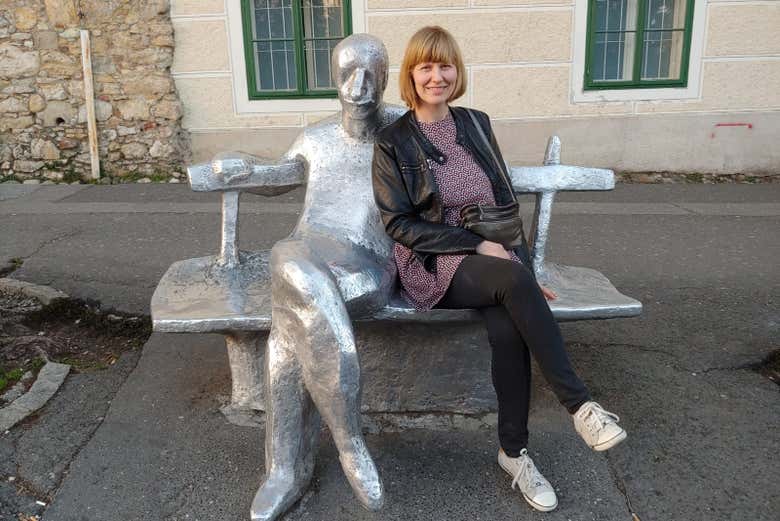 La guida seduta accanto alla statua di Antun Gustav Matoš