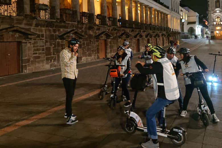 Explicações do guia no tour noturno de patinete