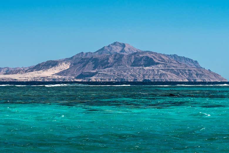 Vue sur les montagnes et l'eau claire de l'île de Tiran