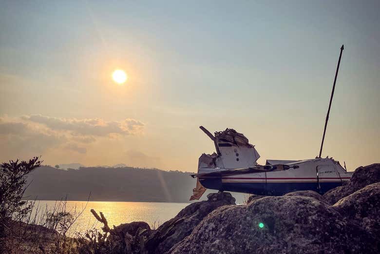 Los vestigios de la avioneta sobre el lago al atardecer