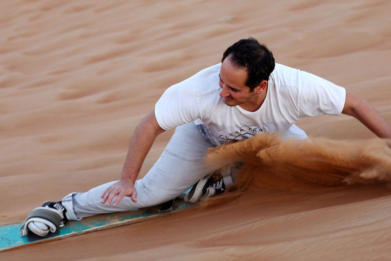 Facendo sandboarding nel deserto