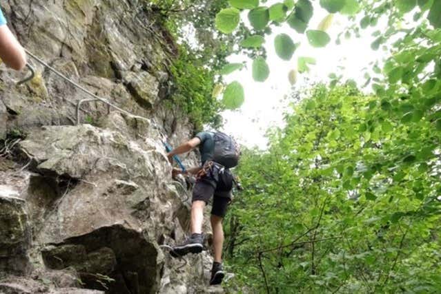 Uma mulher subindo a via ferrata