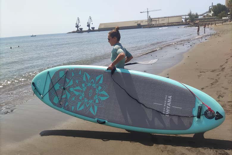 Partecipante entra nell'acqua con la tavola da paddle surf
