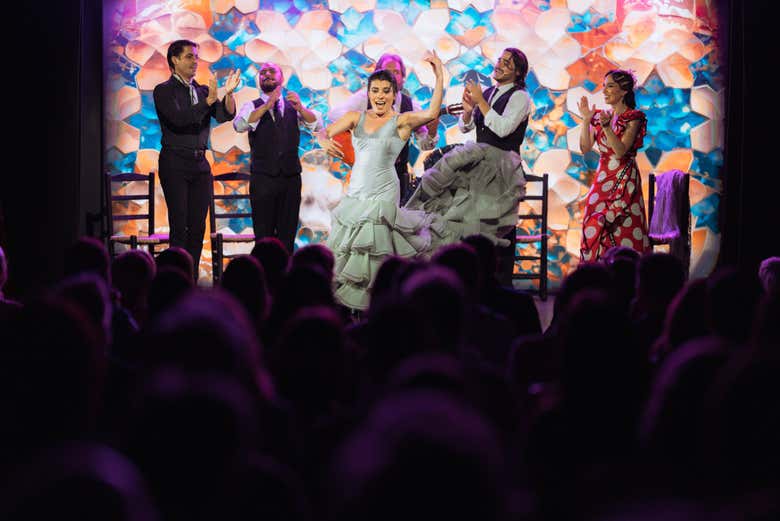 Una bailaora sobre el escenario con bata de cola