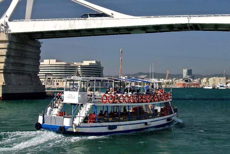 El barco Las Golondrinas pasando bajo un puente de Barcelona