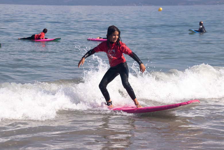 Una ragazza in equilibrio sulla tavola da surf