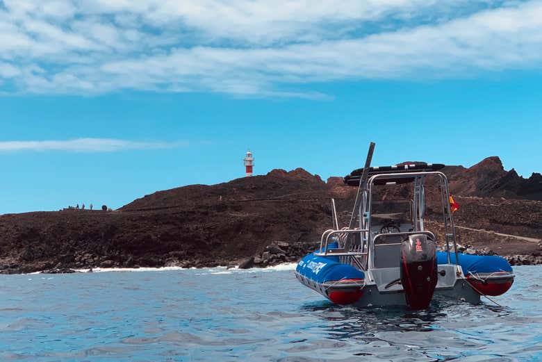 The boat with the Punta de Teno Lighthouse behind