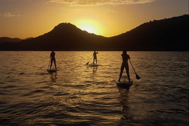Practicando paddle surf al atardecer