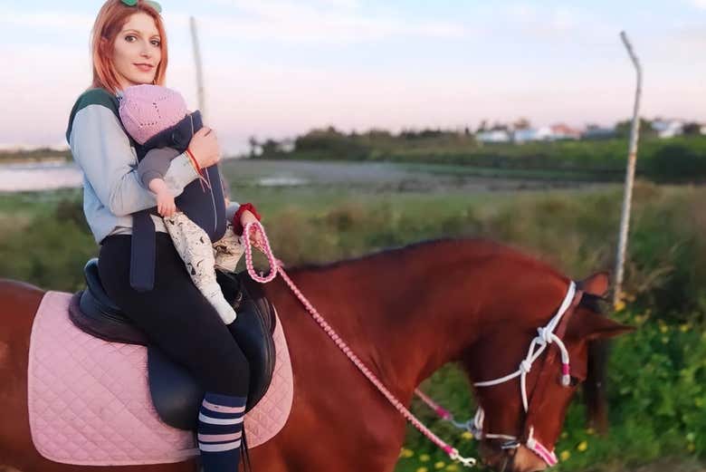 Una mujer y su bebé montando a caballo