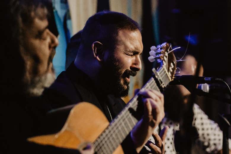 Un músico tocando la guitarra y cantando