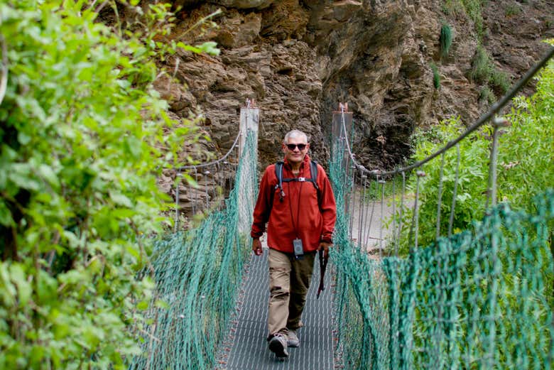 Cruzando un puente colgante en la Vía Verde del Tranvía