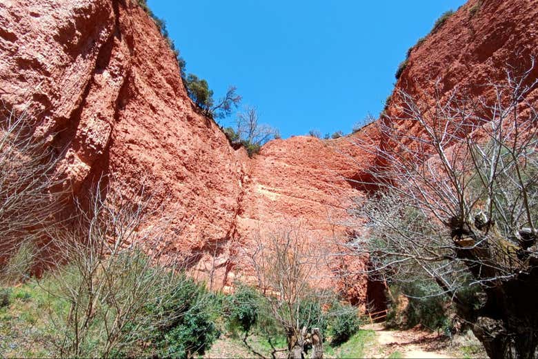 Walk between the red walls of the ancient mine workings