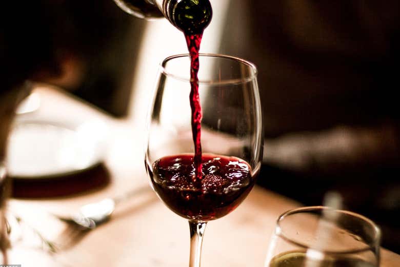 Sirviendo una copa de vino tinto