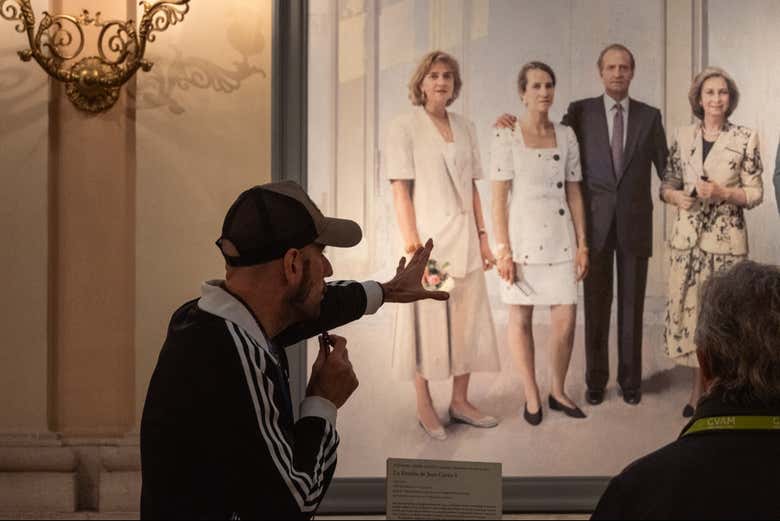 Un guía explicando los detalles de un cuadro de la familia real