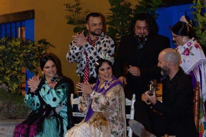 O grupo de flamenco batendo palmas e tocando violão