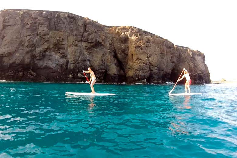 Two people paddle surfing