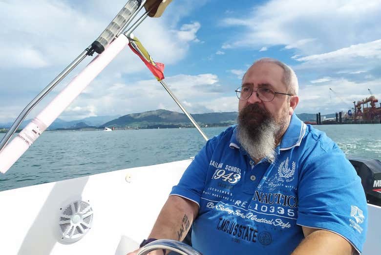 Patrón manejando el timón del barco 