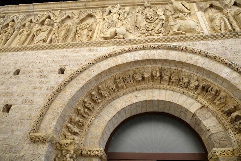 Admirad los relieves esculpidos en el pórtico de piedra